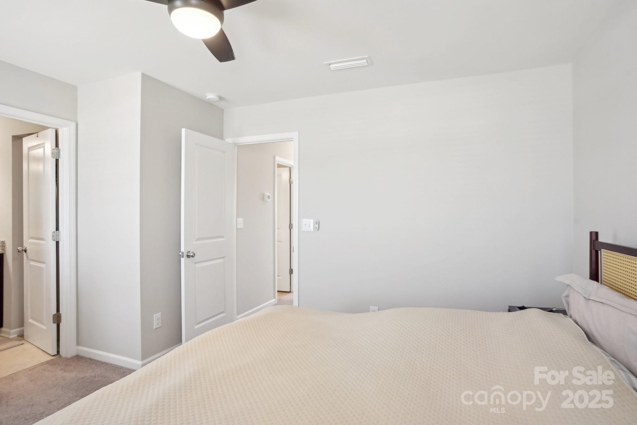 12461 Bryton Ridge Parkway Huntersville, NC 28078 - Photo 16 of 33 a bedroom with a bed and a chandelier fan