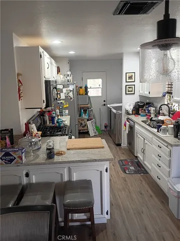 a kitchen with stainless steel appliances granite countertop a stove refrigerator and cabinets