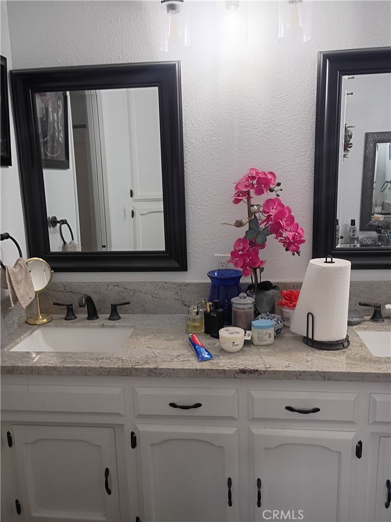 201 South Greenlawn Street Ridgecrest, CA 93555 - Photo 7 of 31 a bathroom with a granite countertop sink and a mirror