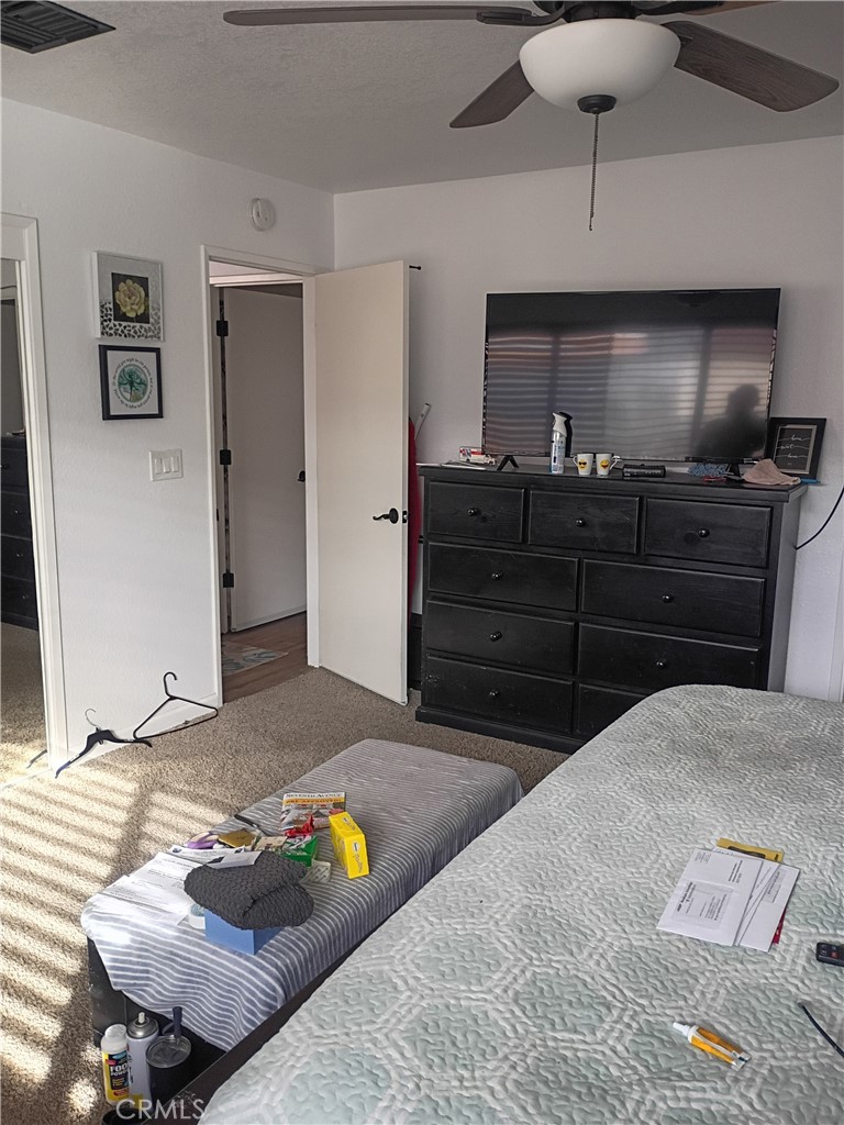 201 South Greenlawn Street Ridgecrest, CA 93555 - Photo 10 of 31 a bedroom with a bed and a chandelier