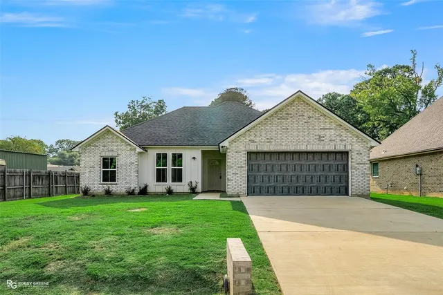 a front view of a house with a garden and yard
