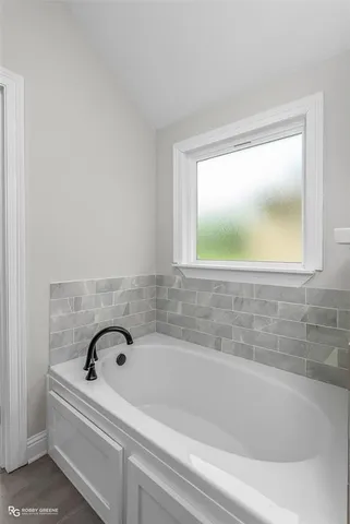 a bathroom with a bathtub and a window