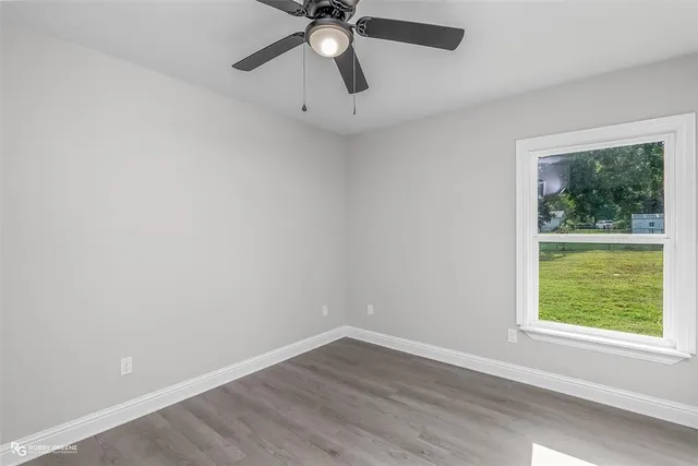 an empty room with a window and a fan