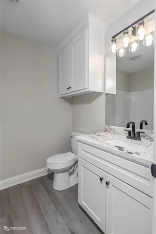 a bathroom with a granite countertop toilet and a sink