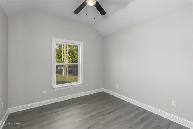 an empty room with a window and a ceiling fan