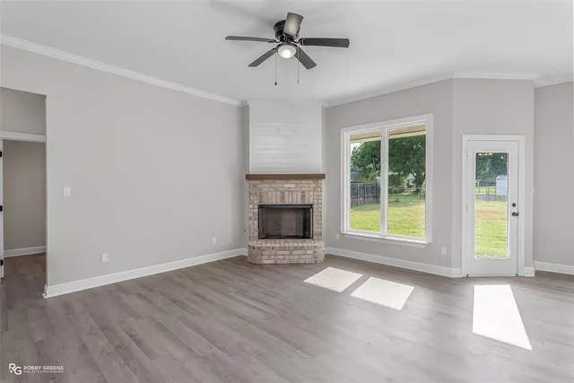 a view of an empty room with a fireplace and a window