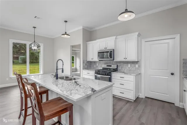 a kitchen with stainless steel appliances granite countertop a stove a refrigerator and microwave