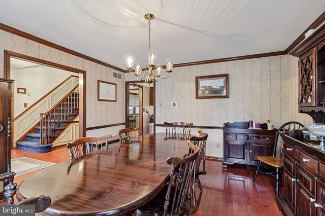 a kitchen with stainless steel appliances kitchen island granite countertop a table chairs and a refrigerator
