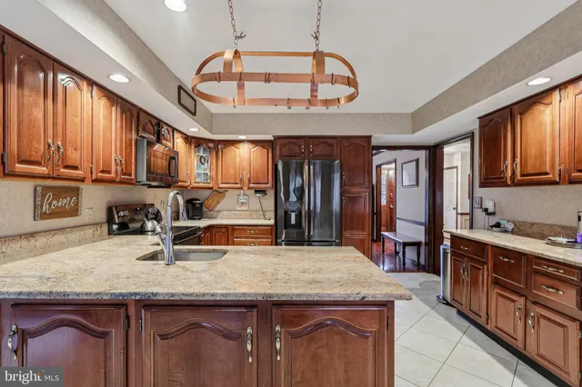 a kitchen with a sink and dishwasher with wooden cabinets