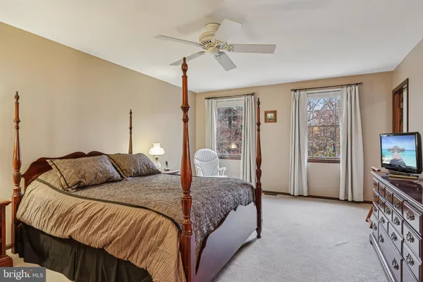 a bedroom with a bed a mirror and a window