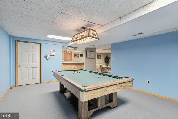 a view of a chairs and table in the backyard with a barbeque