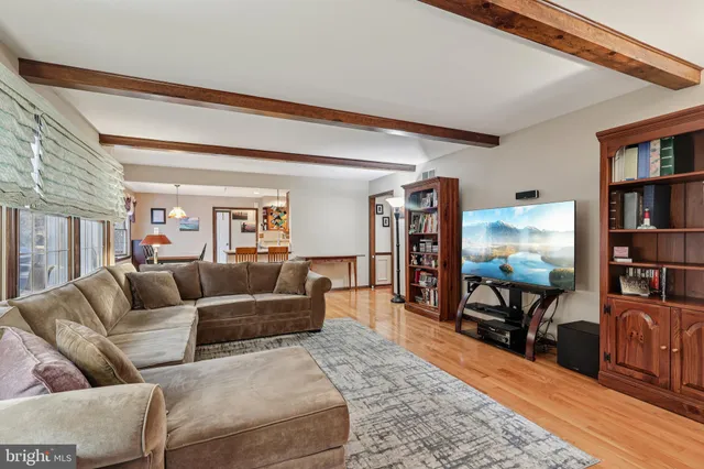 a view of a dining room and livingroom with furniture wooden floor a chandelier