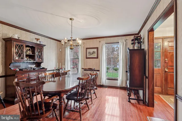 a view of a dining room with furniture a chandelier and wooden floor