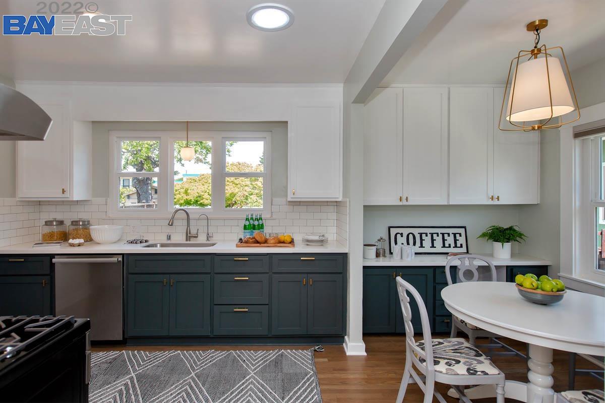a kitchen with stainless steel appliances a sink a stove a table and chairs