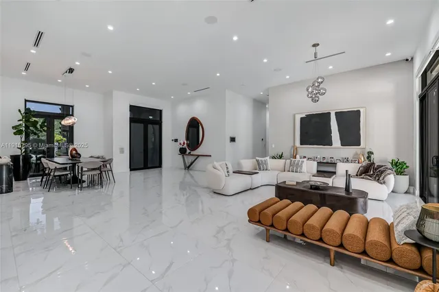 a living room with furniture kitchen view and a large window