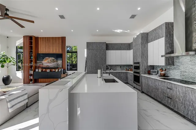 a living room with furniture and a view of kitchen