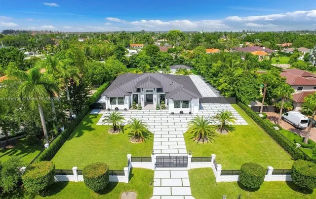 a aerial view of a house with swimming pool and green yard