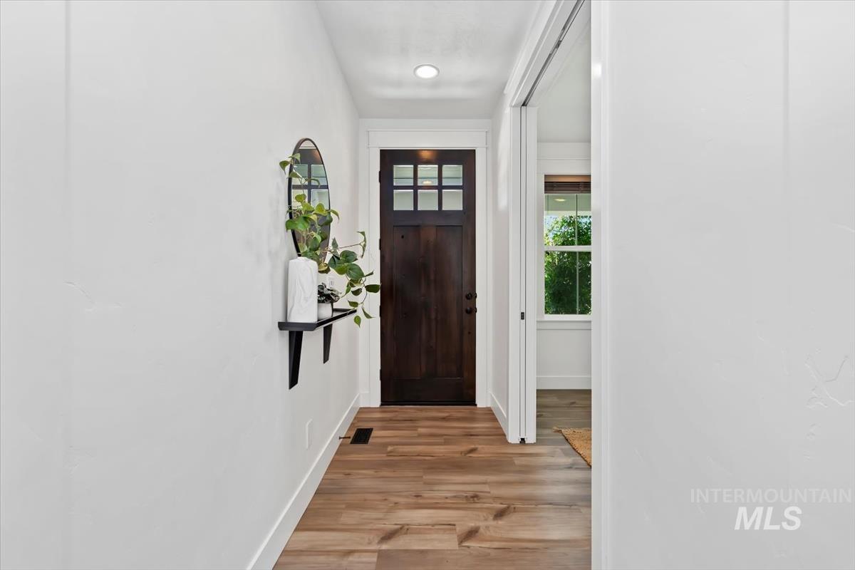 5897 West Riva Capri Street Meridian, ID 83646 - Photo 29 of 50 Entryway featuring a dark wood door with glass panes, wood-finish flooring, recessed lighting, and crisp white baseboards