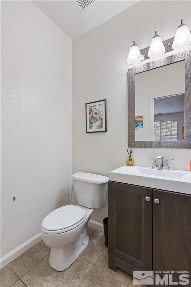 1859 Resistol Drive Reno, NV 89521 - Photo 14 of 33 a bathroom with a toilet a sink and mirror