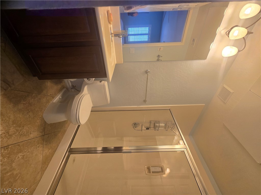 2567 Dirleton Place Henderson, NV 89044 - Photo 52 of 67 Casita Bathroom with walk-in closet. A well-appointed bathroom features a glass-enclosed shower, a modern vanity, and practical tile flooring.