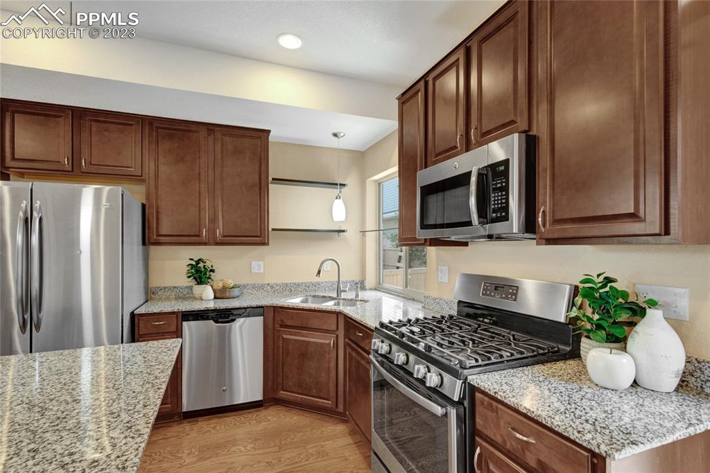 4118 Elegant Street Castle Rock, CO 80109 - Photo 11 of 26 a kitchen with stainless steel appliances granite countertop a refrigerator stove a sink dishwasher and microwave oven