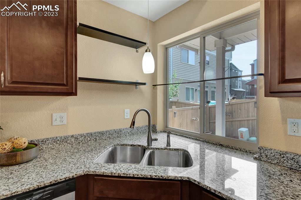 4118 Elegant Street Castle Rock, CO 80109 - Photo 12 of 26 a kitchen with granite countertop a sink and a wooden floor