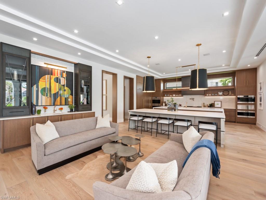 349 Colony Drive Naples, FL 34108 - Photo 16 of 48 Living room featuring a tray ceiling and light hardwood / wood-style floors