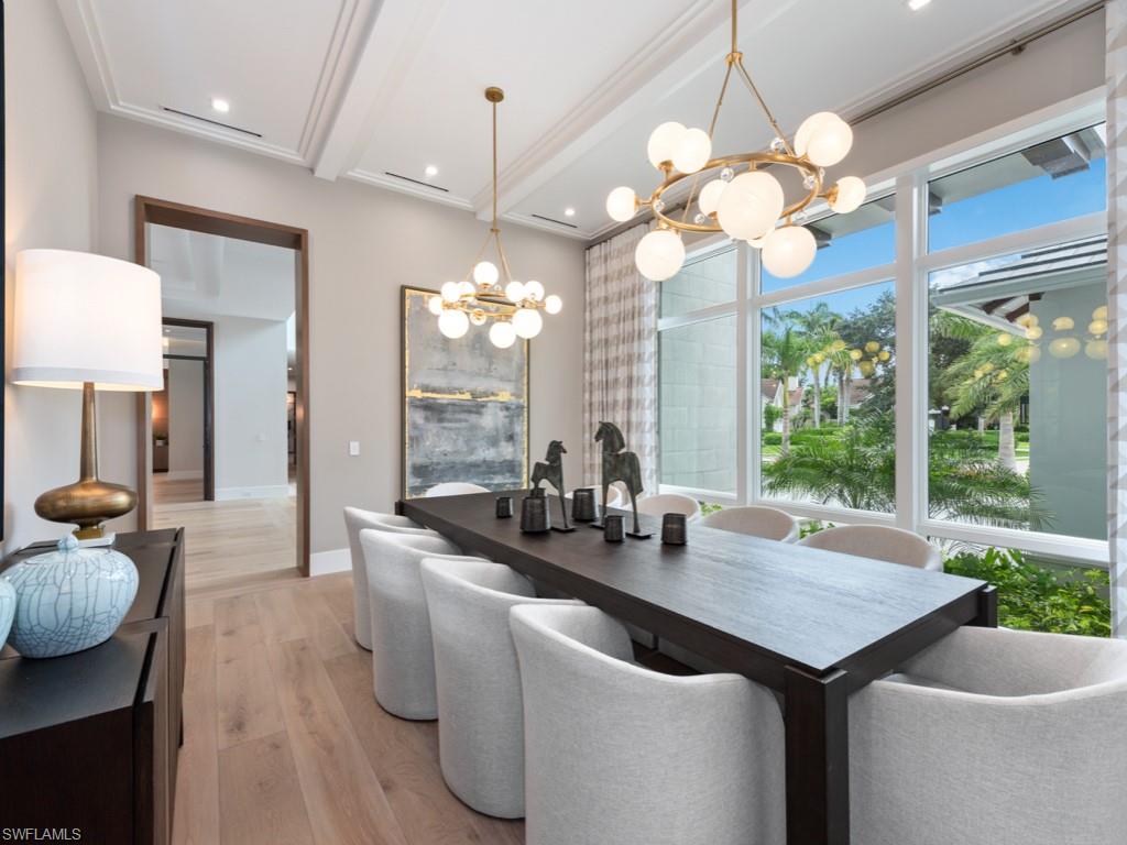 349 Colony Drive Naples, FL 34108 - Photo 18 of 48 Dining space with ornamental molding, an inviting chandelier, beam ceiling, and light hardwood / wood-style floors