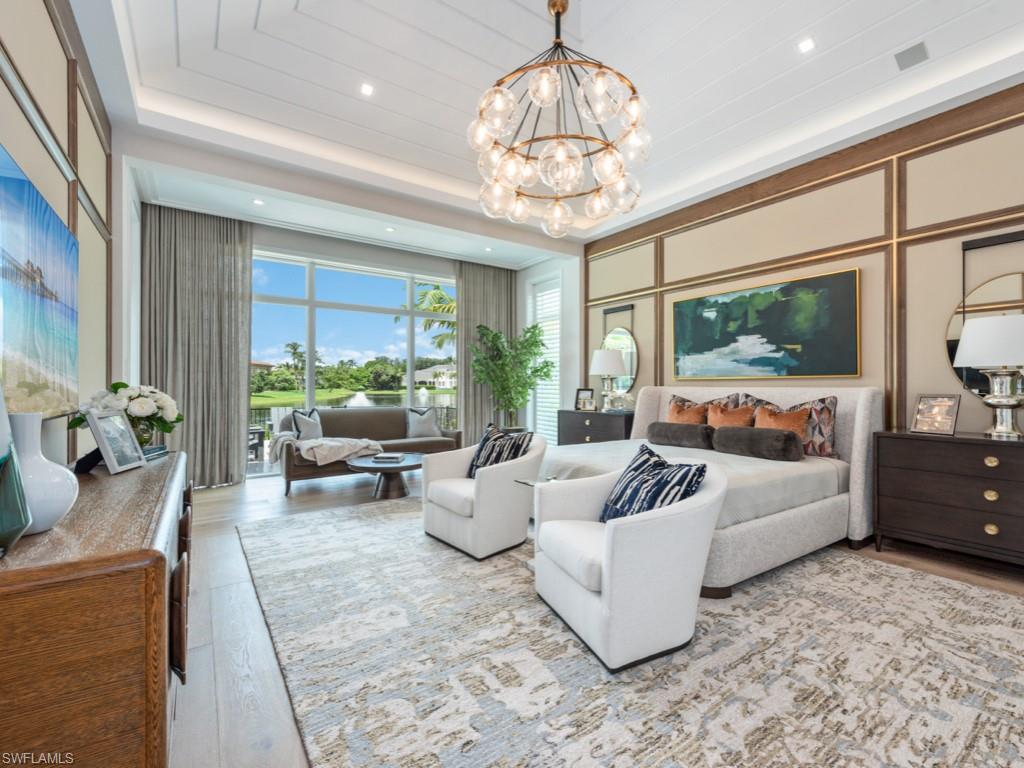 349 Colony Drive Naples, FL 34108 - Photo 23 of 48 Bedroom with a raised ceiling, a notable chandelier, and light hardwood / wood-style flooring