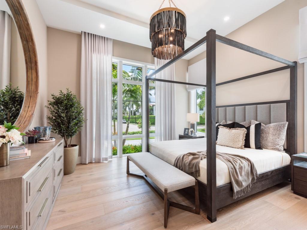349 Colony Drive Naples, FL 34108 - Photo 27 of 48 Bedroom with multiple windows, a chandelier, and light hardwood / wood-style floors