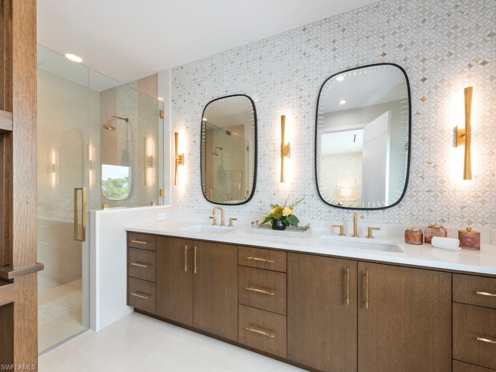 349 Colony Drive Naples, FL 34108 - Photo 30 of 48 Bathroom with tile walls, walk in shower, decorative backsplash, and vanity