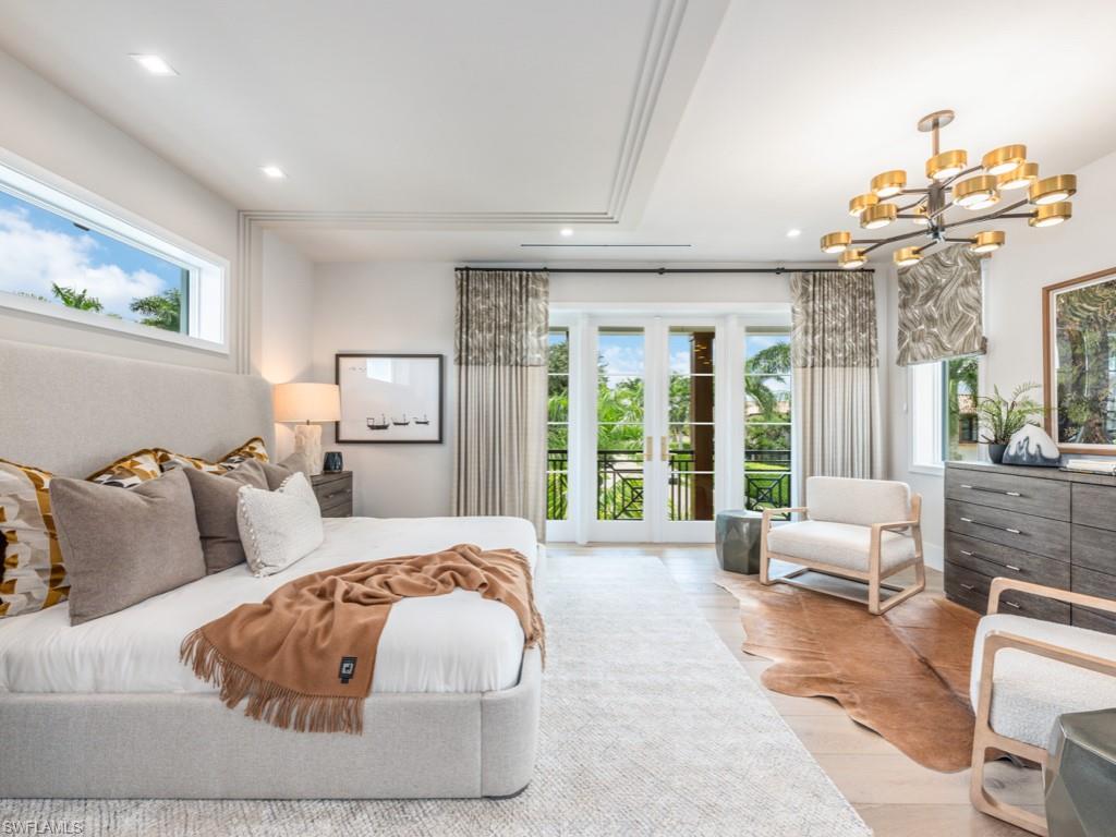 349 Colony Drive Naples, FL 34108 - Photo 33 of 48 Bedroom with light hardwood / wood-style flooring, a notable chandelier, multiple windows, and access to outside