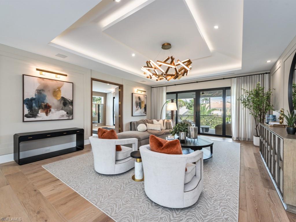 349 Colony Drive Naples, FL 34108 - Photo 34 of 48 Living room with a raised ceiling, a wealth of natural light, and light hardwood / wood-style floors
