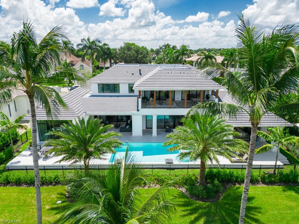 349 Colony Drive Naples, FL 34108 - Photo 4 of 48 Rear view of property featuring a yard, a fenced in pool, and a patio area