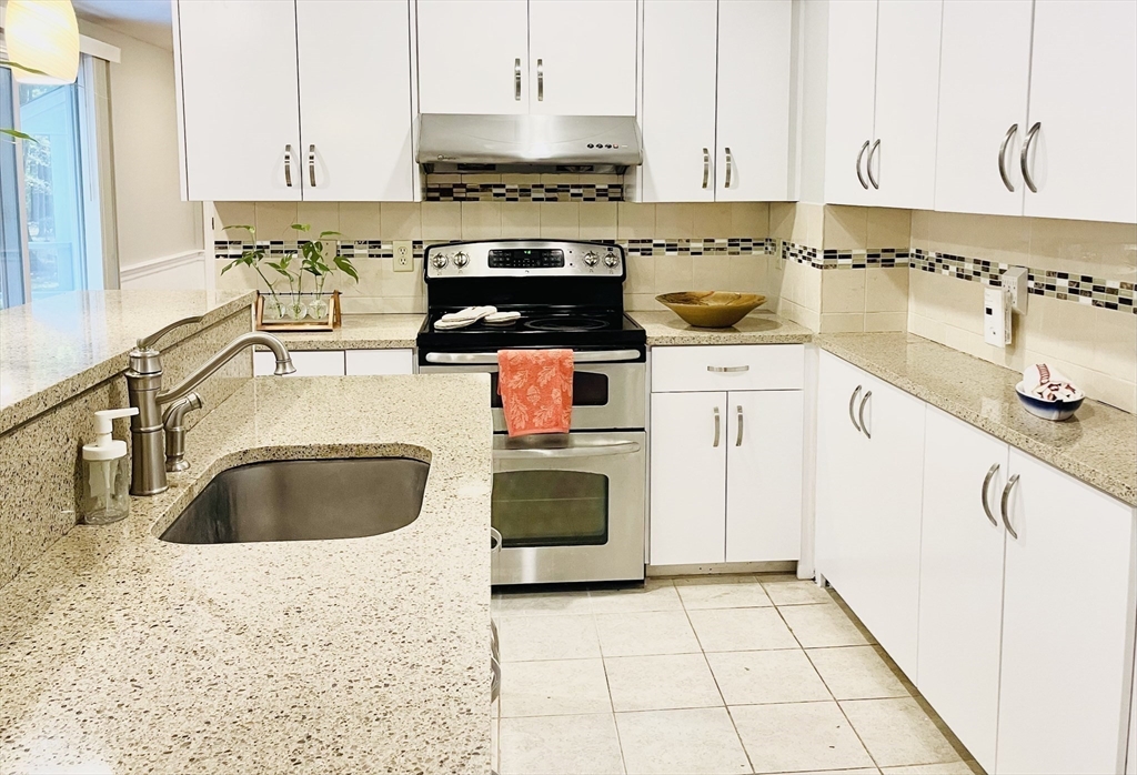 42 Jackson Drive Acton, MA 01720 - Photo 13 of 39 a kitchen with granite countertop a stove a sink and a granite counter tops