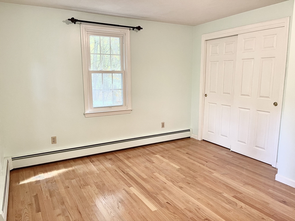42 Jackson Drive Acton, MA 01720 - Photo 31 of 39 an empty room with wooden floor and windows