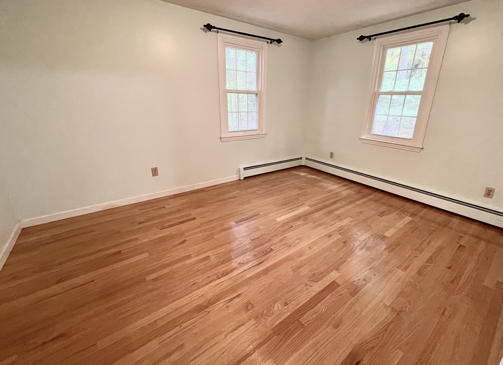 42 Jackson Drive Acton, MA 01720 - Photo 32 of 39 an empty room with wooden floor and windows