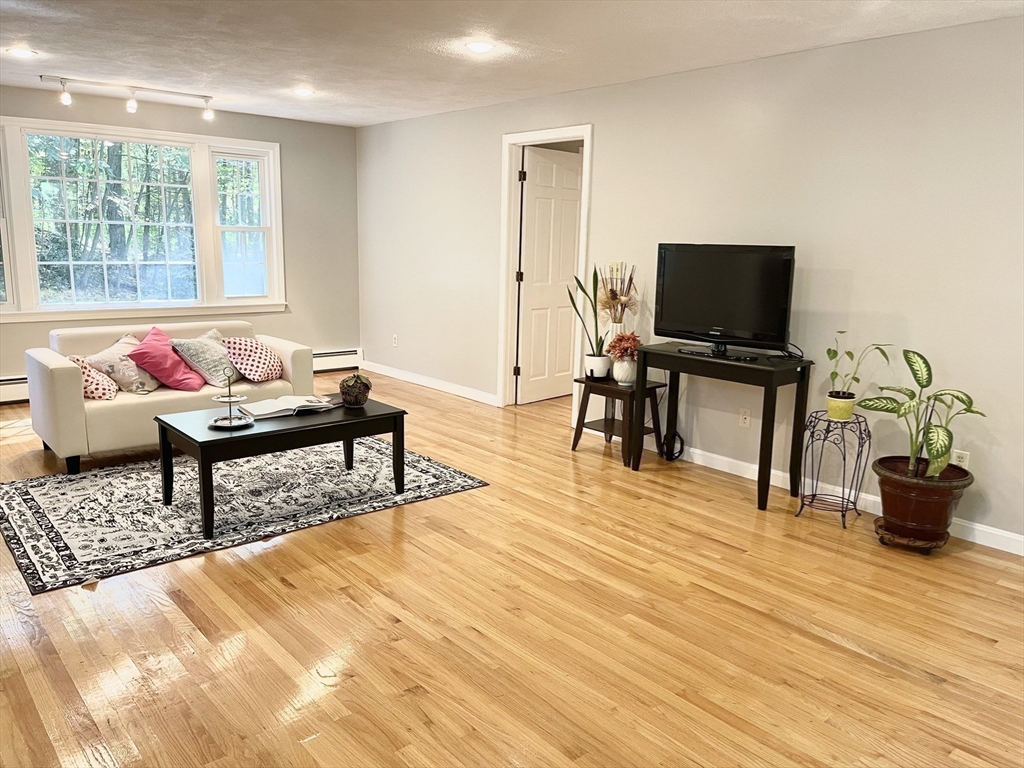 42 Jackson Drive Acton, MA 01720 - Photo 5 of 39 a living room with furniture and a flat screen tv