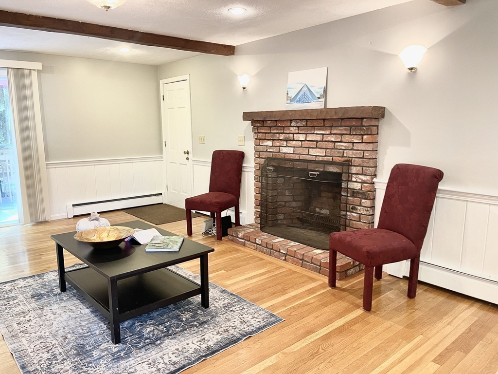 42 Jackson Drive Acton, MA 01720 - Photo 10 of 39 a living room with furniture a fireplace and a table