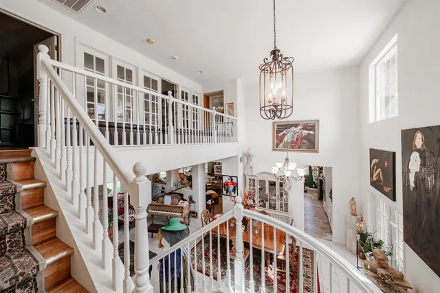 a view of an entryway wooden floor and chandelier