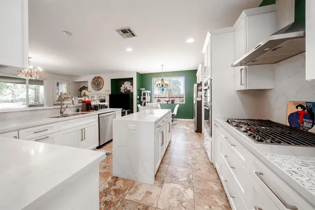 a kitchen with white cabinets and appliances