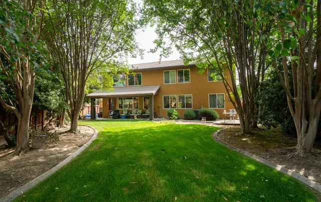 a view of a house with backyard and a tree