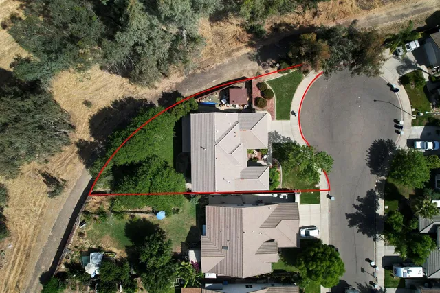 an aerial view of a house with outdoor space and swimming pool