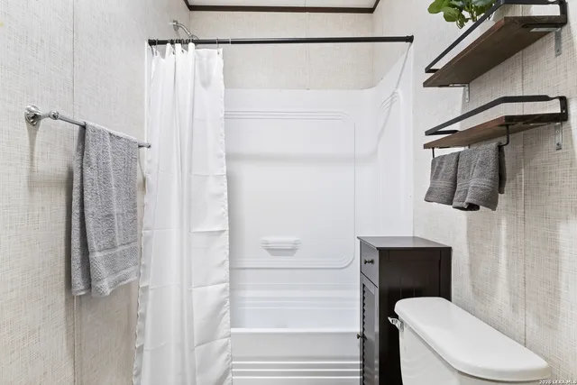 a bathroom with a shower a toilet and sink