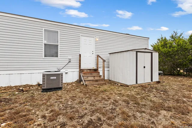 a view of a house with backyard and a tree