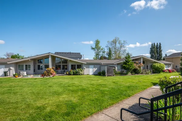 a view of a house with a yard and sitting area