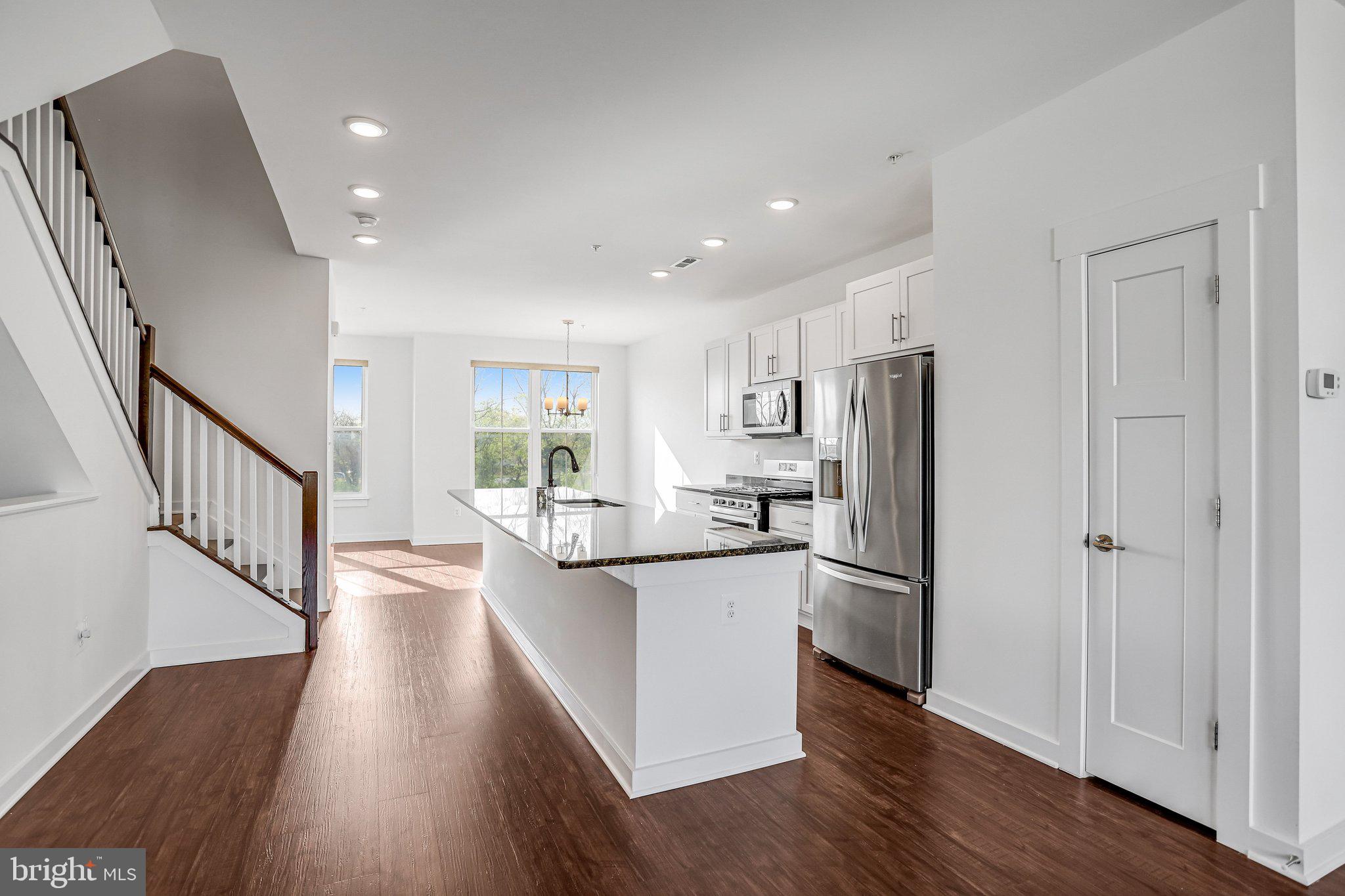 1203 Furgeson Lane Frederick, MD 21702 - Photo 3 of 16 a kitchen with stainless steel appliances a refrigerator oven a sink dishwasher and white cabinets with wooden floor
