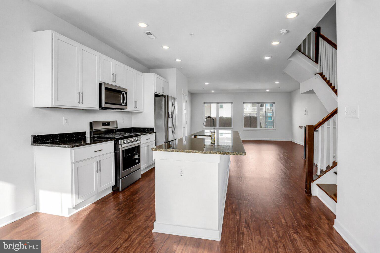 1203 Furgeson Lane Frederick, MD 21702 - Photo 7 of 16 a kitchen with stainless steel appliances kitchen island granite countertop a stove a sink and a microwave