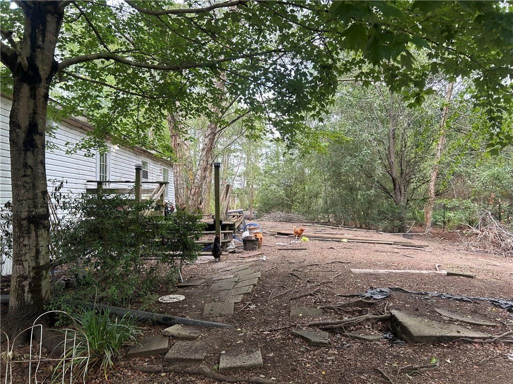 114 Jones Road Hortense, GA 31543 - Photo 13 of 25 a backyard of a house with table and chairs under a large tree