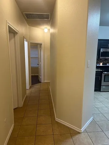 a view of a hallway with wooden shelves